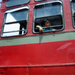 印度孟买，一个男孩从公交车窗户向外看。图片来源:gregor_y